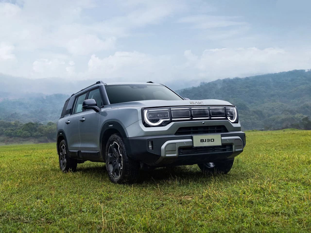 Silver BAIC BJ30e on a grassy field, front three-quarter view
