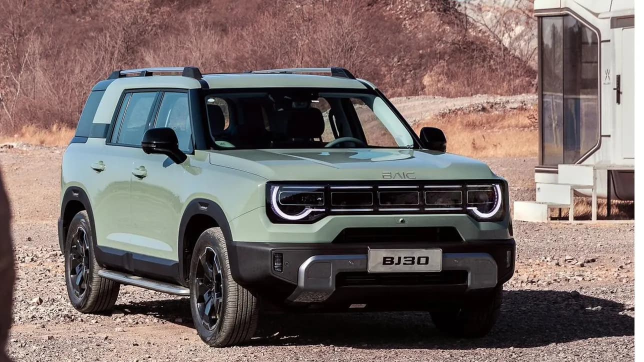 Sage green BAIC BJ30e on a gravel track beside a trailer