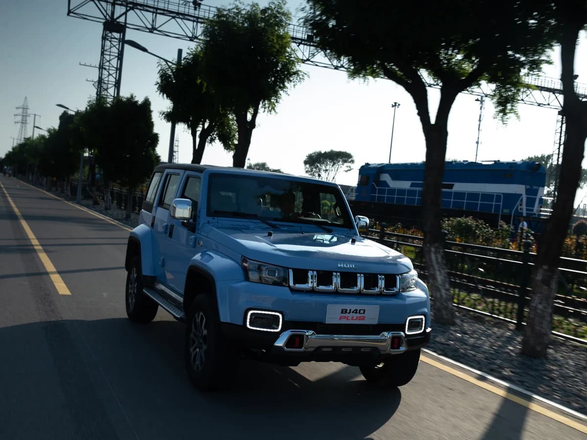Sky Blue BAIC BJ40 Plus on a tree-lined road