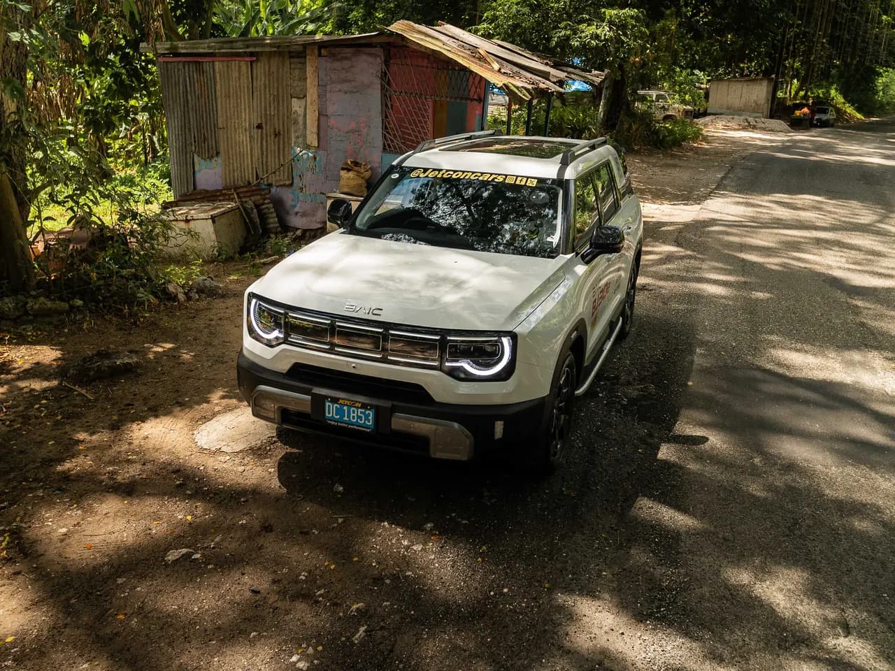 White BAIC BJ30e on a shaded rural road, seen from a high front three-quarter angle